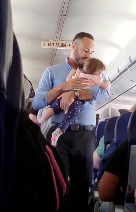flight attendant comforts baby
