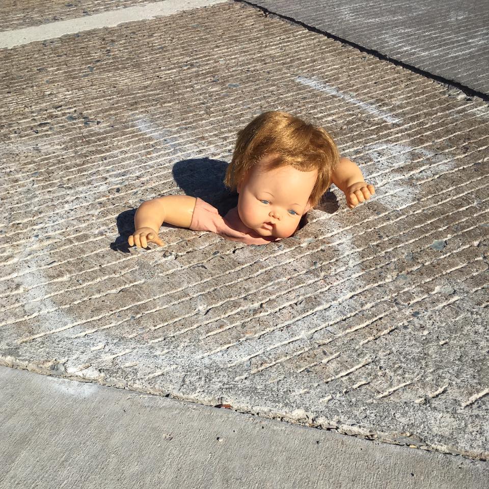 doll in crosswalk hole