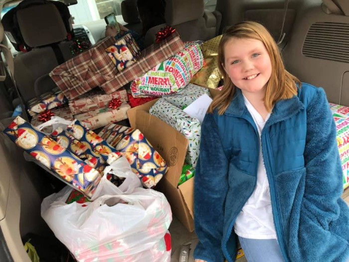 Katy in front of pile of Christmas presents 