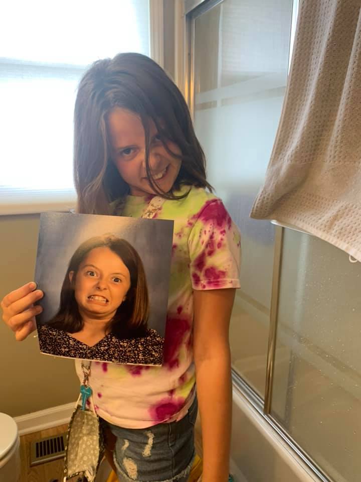 a girl making a funny face as she holds up a picture of herself making a funny face