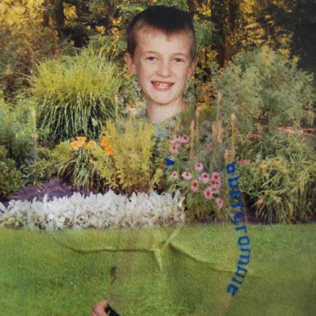 a photo of a boy that just looks like a floating head in a background of flowers
