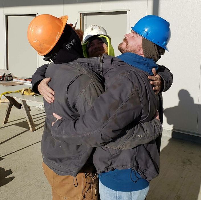 construction workers hugging