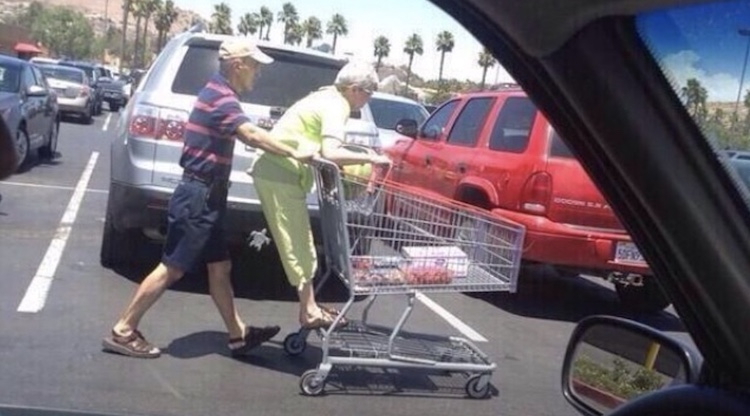man pushing wife on grocery cart