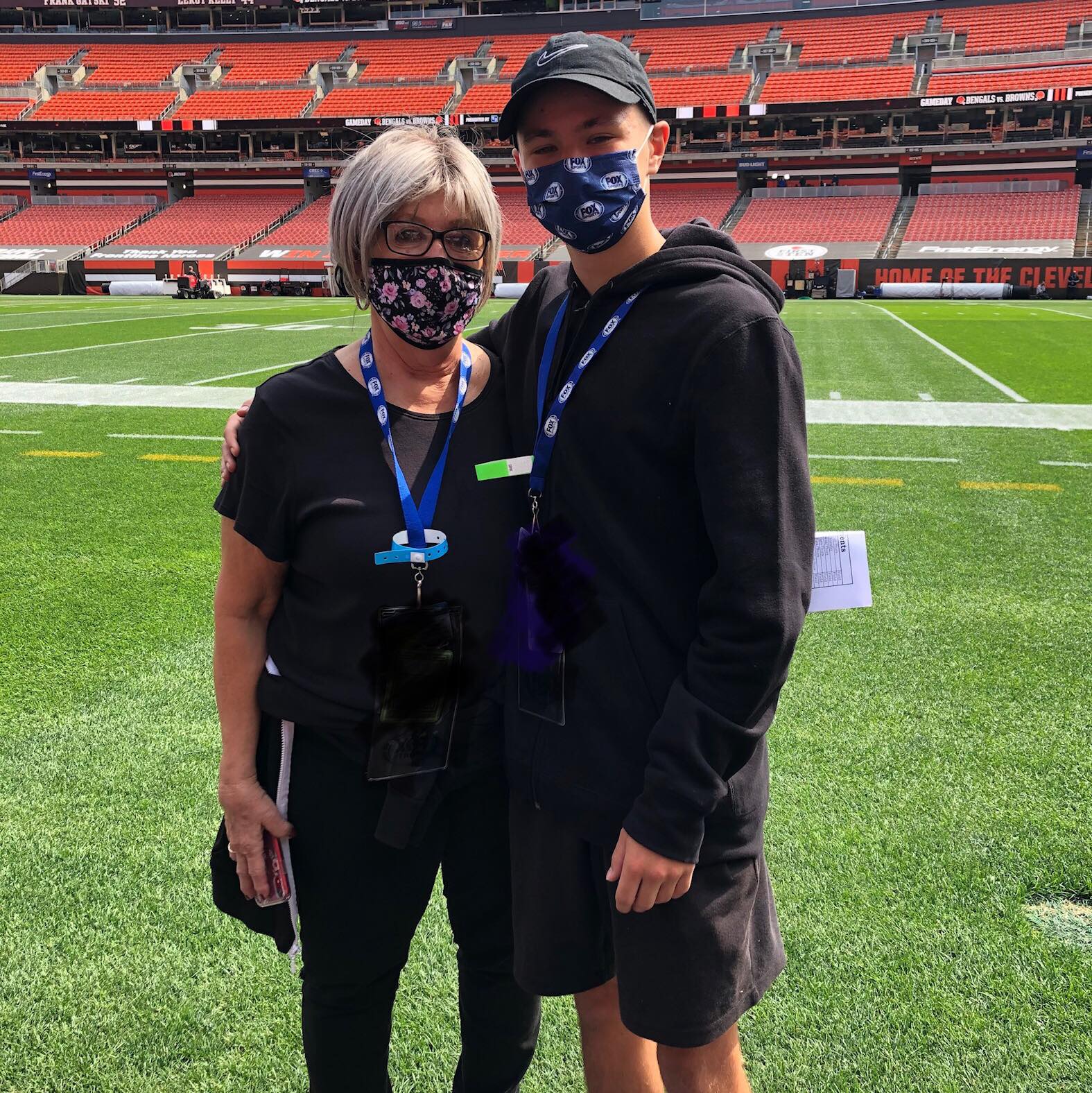 mom and son standing on football field