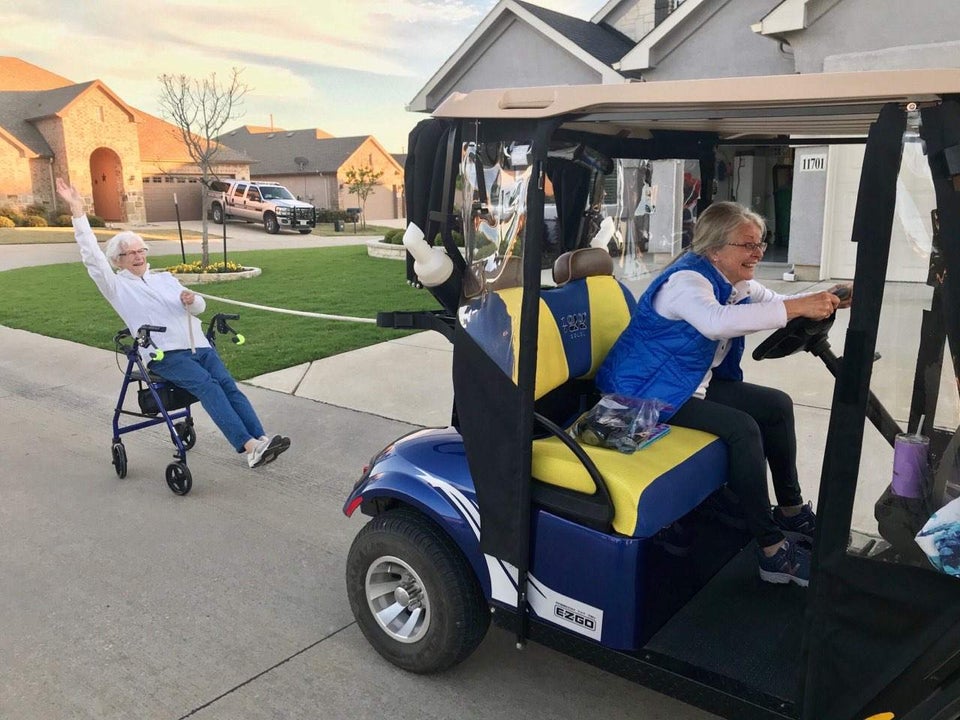 grandpa in golf cart pulling grandma sitting on walker 