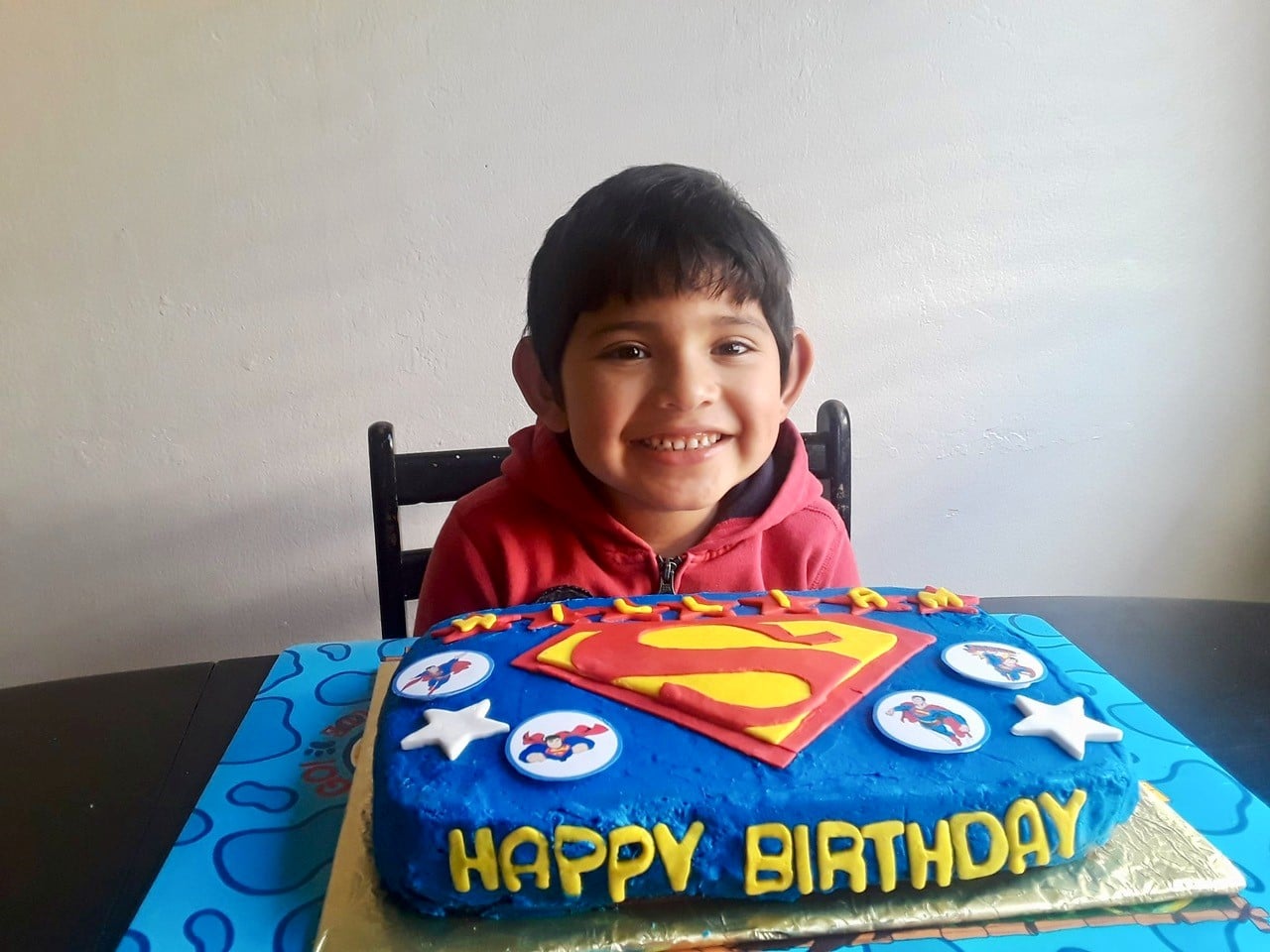 boy smiling with superman cake