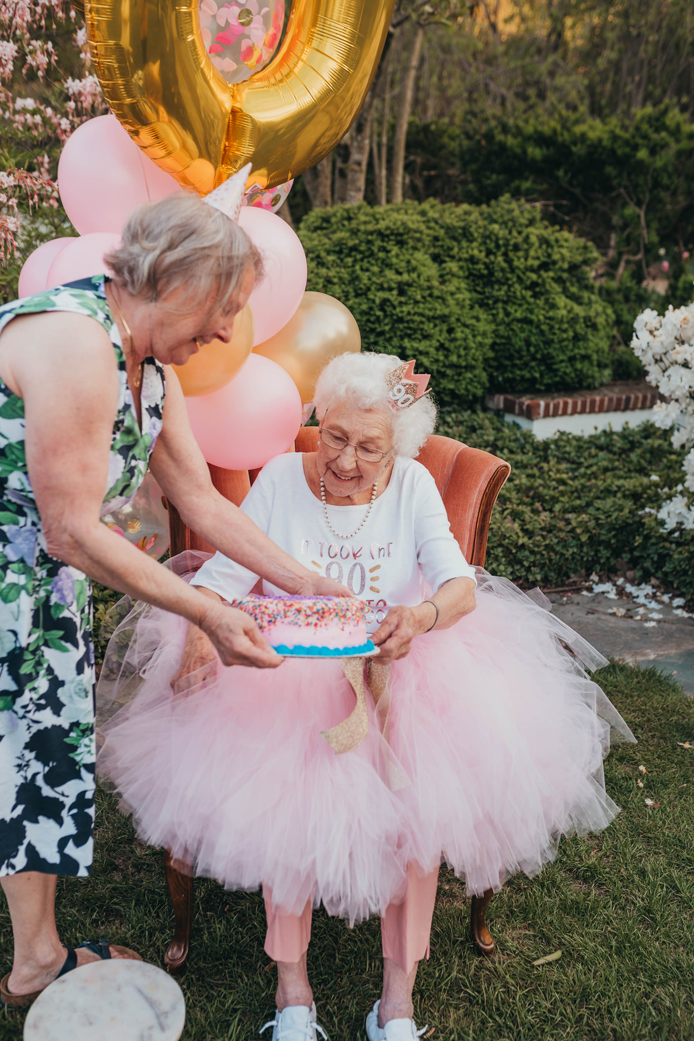 woman handing grandma a birthday cake