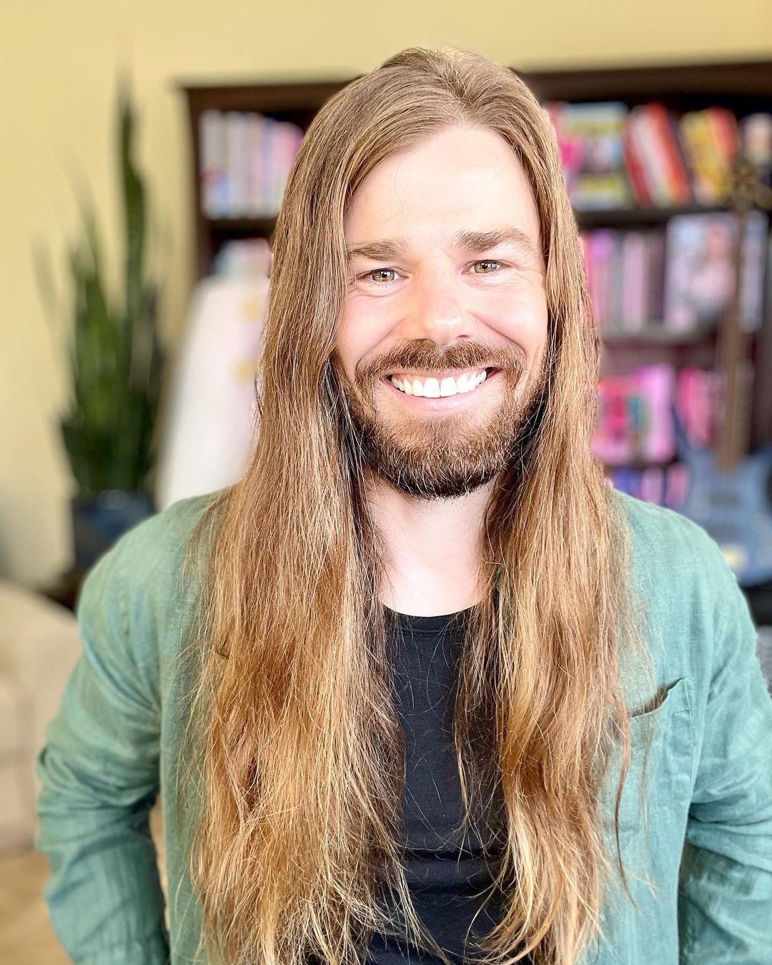 man with long hair and a beard smiling