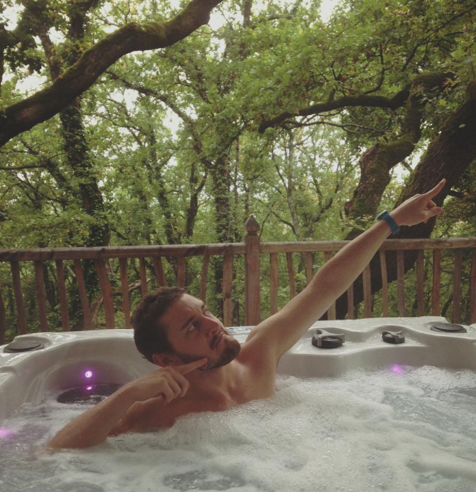 man pointing up at the sky while in a hot tub