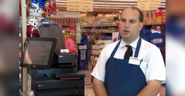grocery store clerk talking next to cash register