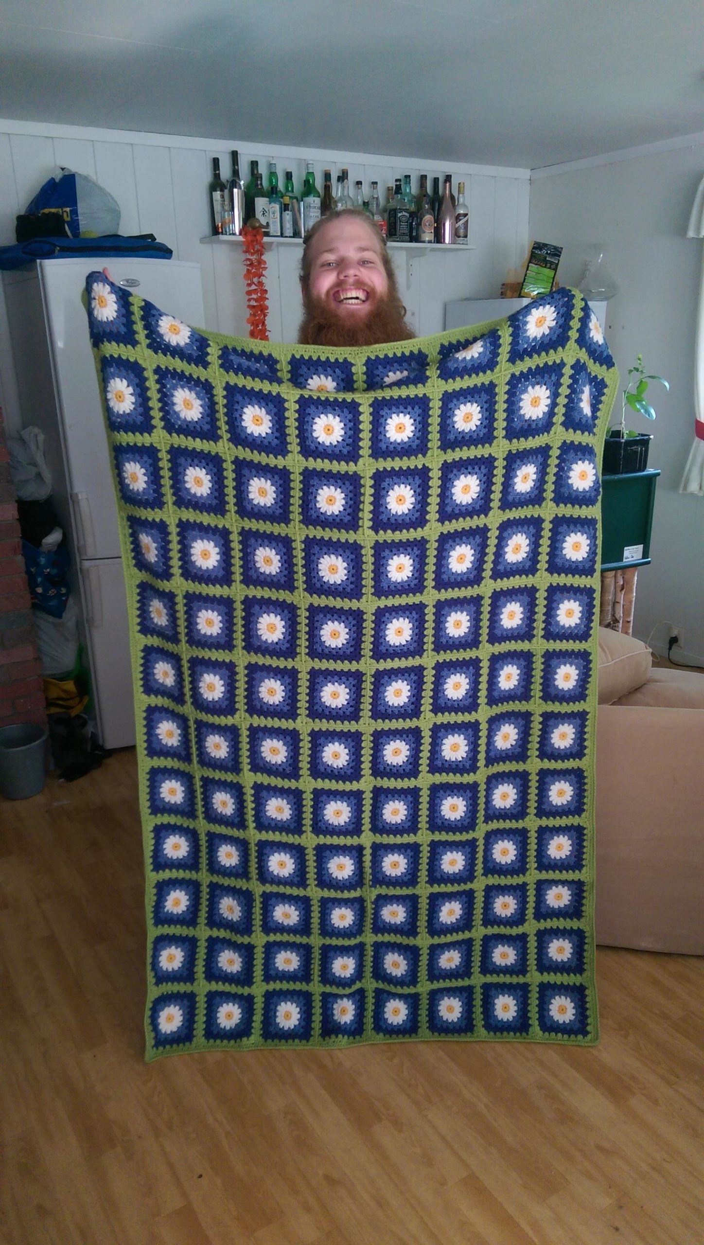 man holding crochet daisy blanket