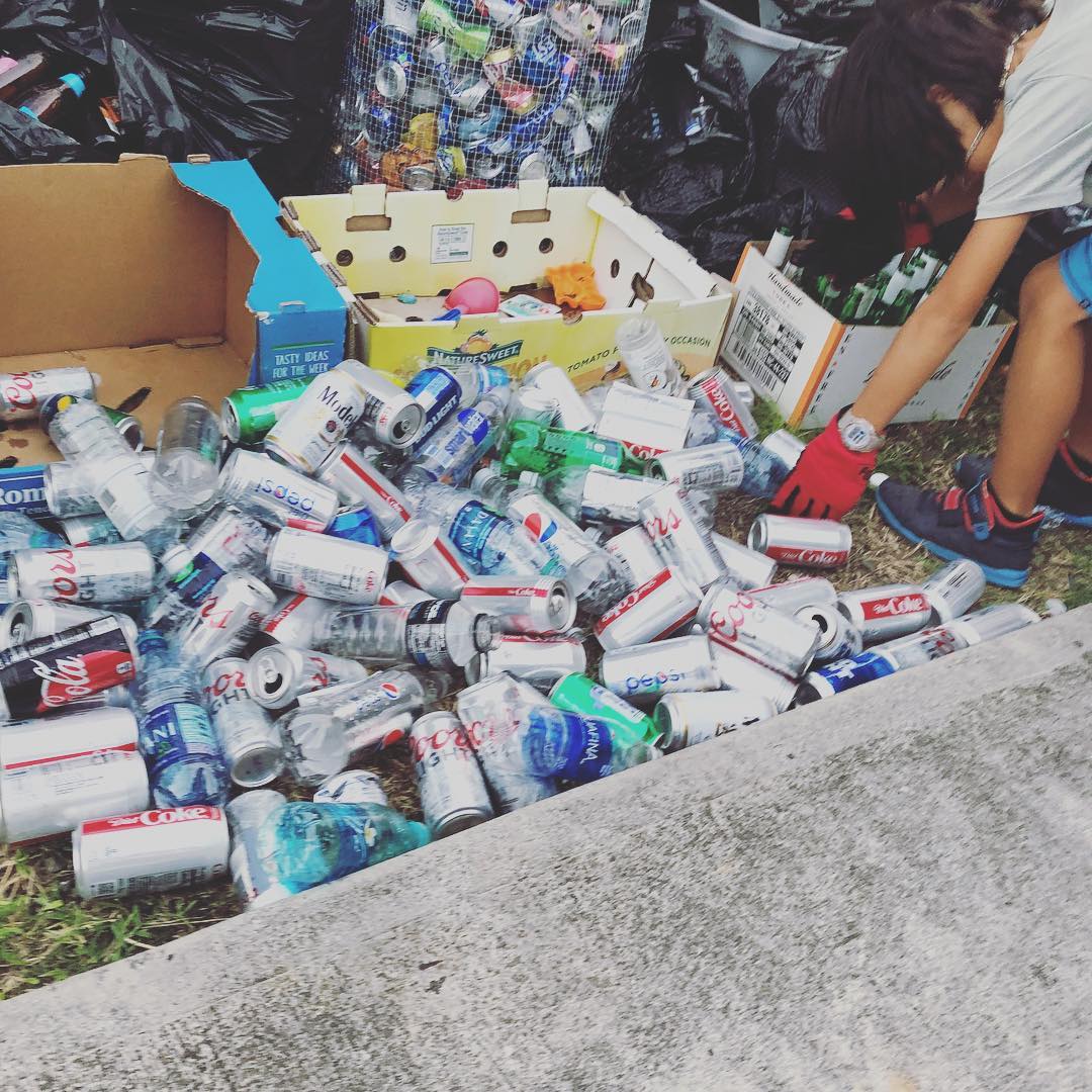 boy collecting cans and bottles from large pile