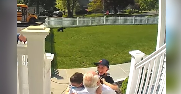 two boys hugging grandpa on porch