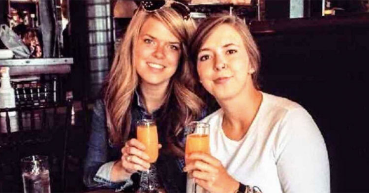 sisters at restaurant holding glasses