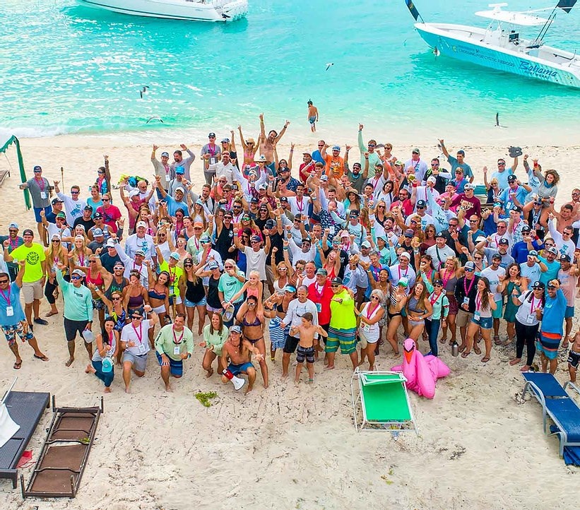 aerial view of a large group of people posing on a beach