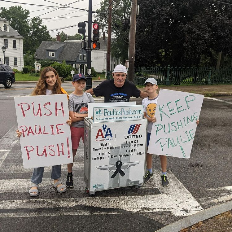 man posing with children holding signs