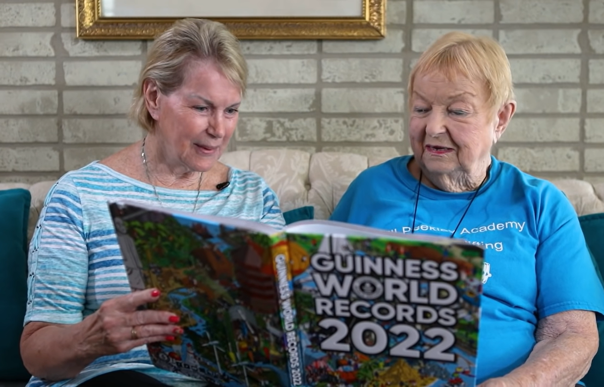 women looking at "Guinness World Records 2022" book