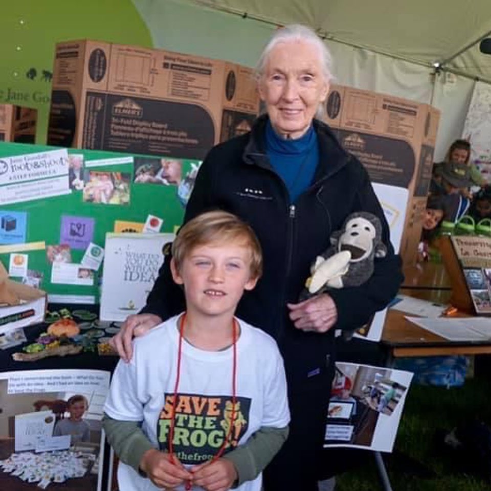 little boy wearing "save the frog" shirt next to dr. jane goodall