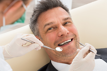 man smiling up at dentist
