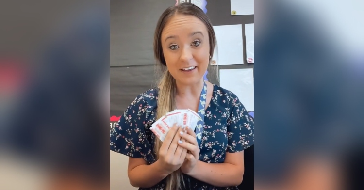 young woman talking while holding up a fanned out stack of band aids