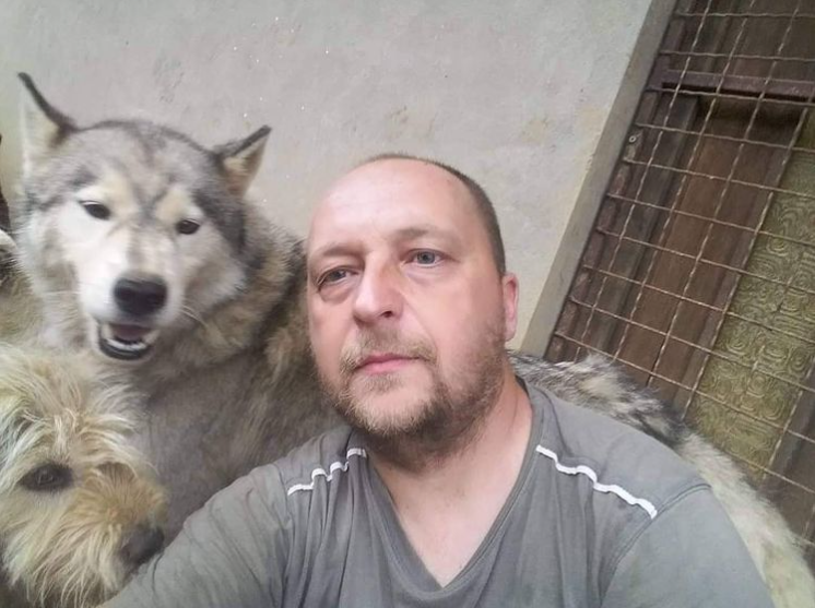 man posing with two dogs