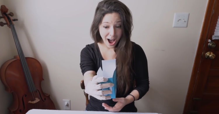 woman using a bionic arm shocked that she is holding a box in her hand