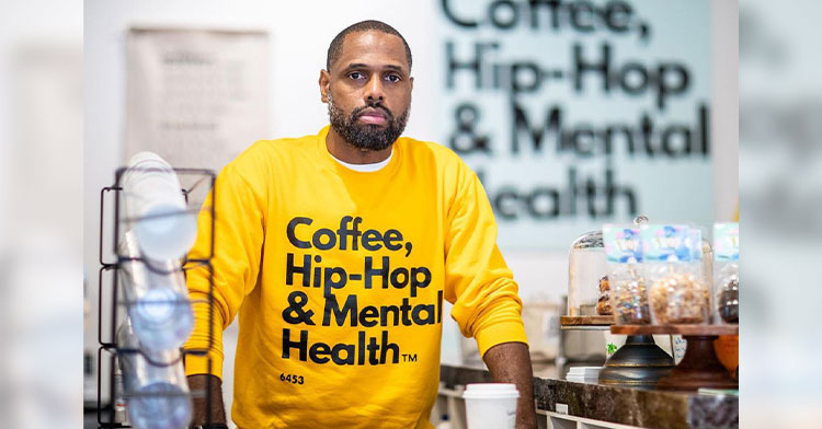 man standing in mental health focused coffee shop
