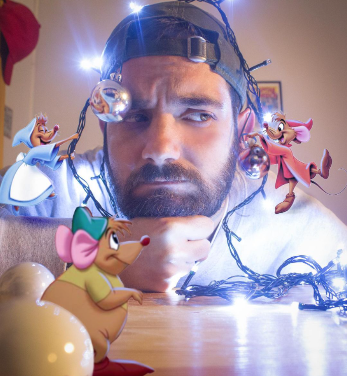man resting his head on his hand on a table, tangled in lights that are being strung by photoshop versions of the mice from cinderella