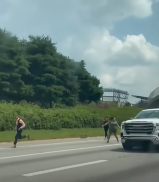 people running beside a truck trying to get the driver's attention