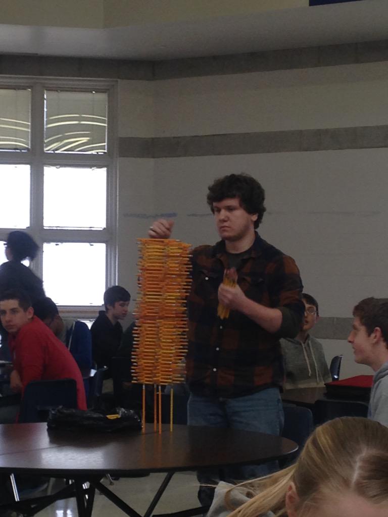 teen stacking hundreds of pencils in cafeteria