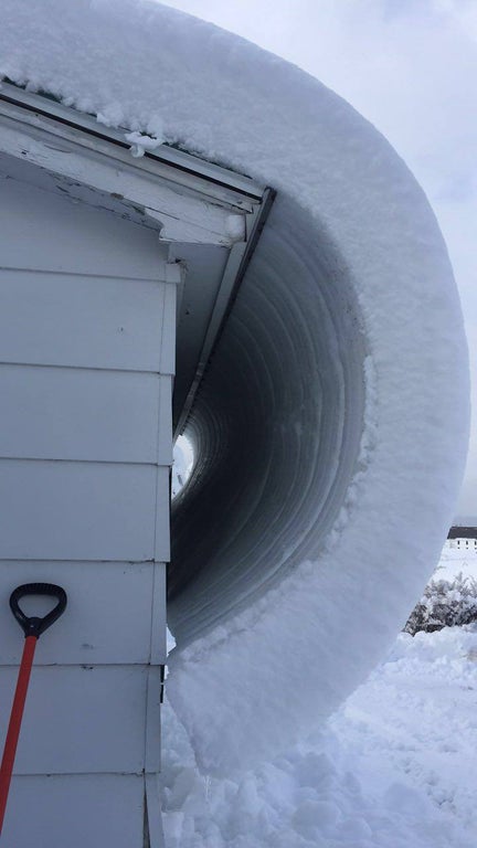 snow curving over side of building