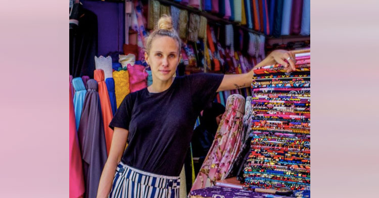 woman standing next to textiles