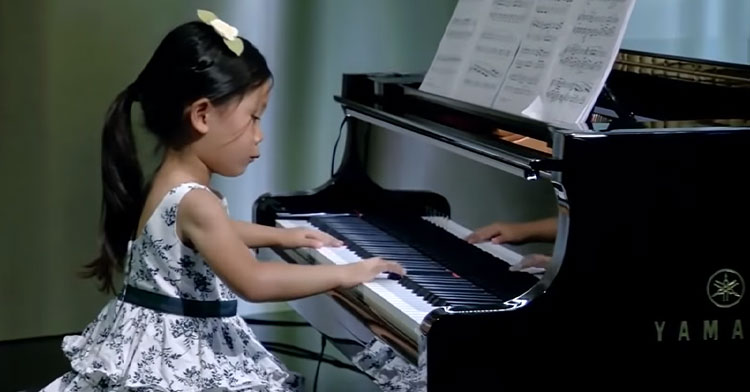 little girl plays piano