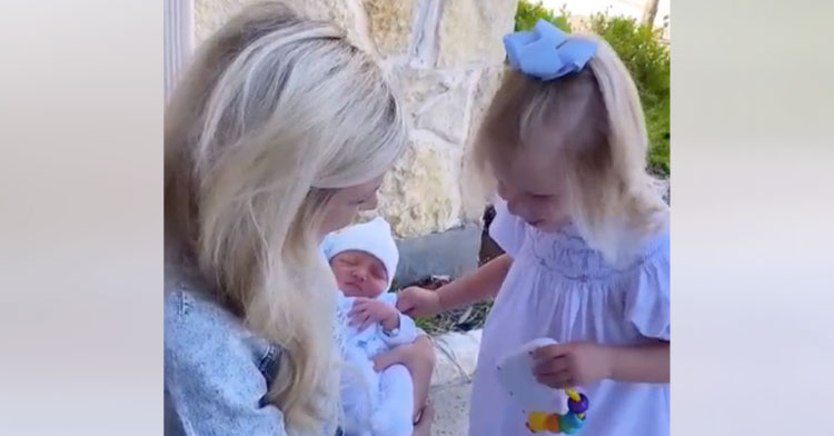 blind little girl touching baby brother's head