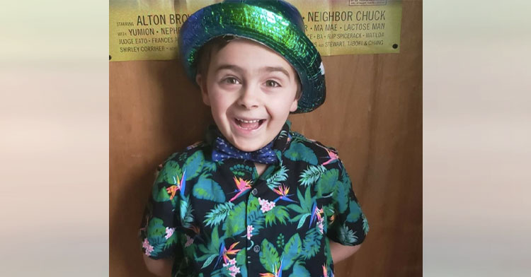 little boy smiling with tropical shirt