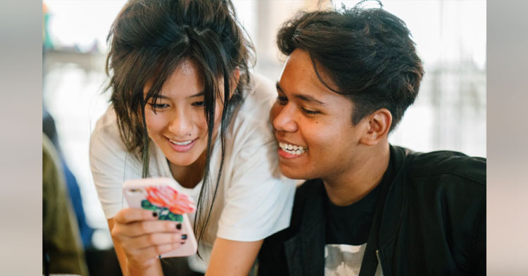 teens hanging out looking at phone