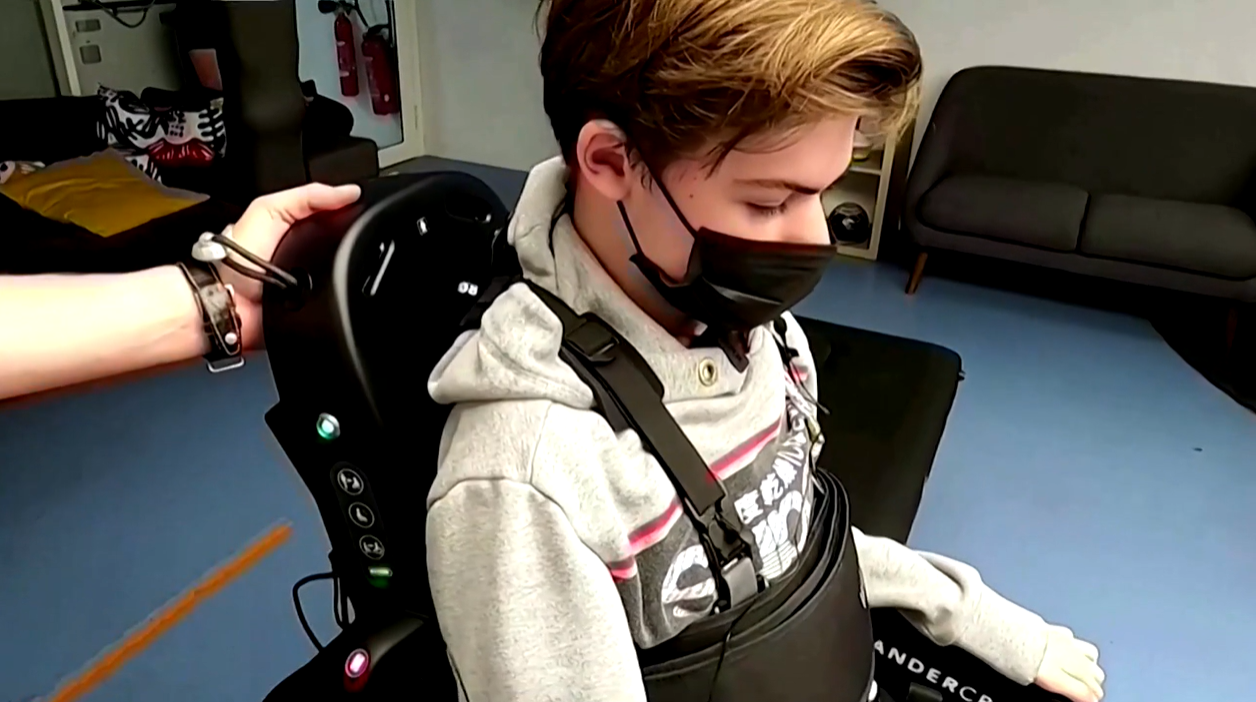 teenager wearing mask and exoskeleton robot