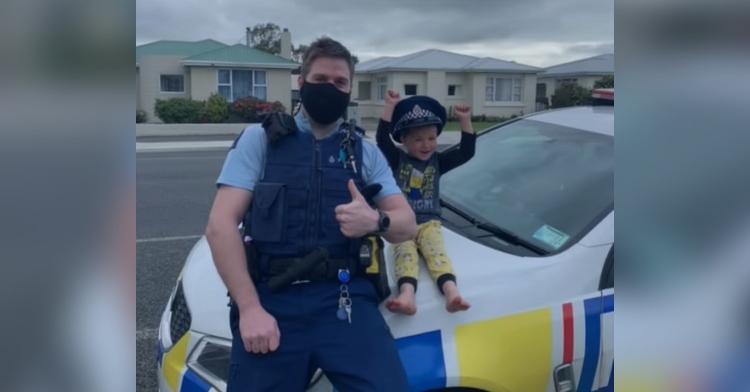New Zealand police officer and little boy wearing his hat