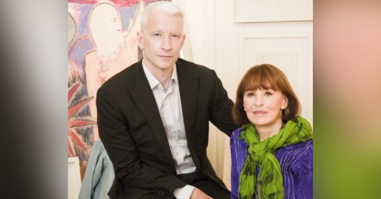anderson cooper and his mom gloria vanderbilt sitting in front of an art piece and smiling