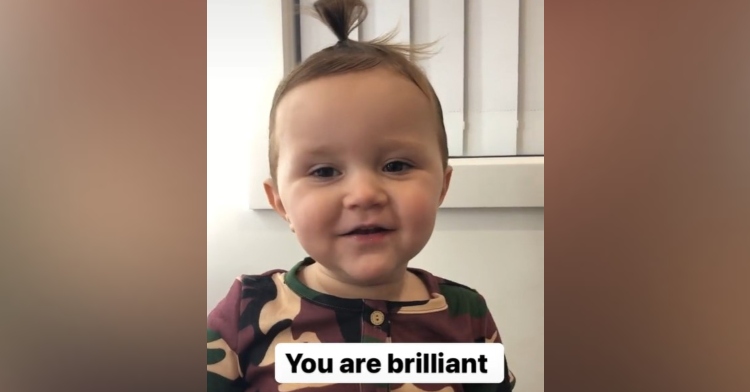 2 year old girl with hair in a top bun saying affirmations with the words "you are brilliant" on the image
