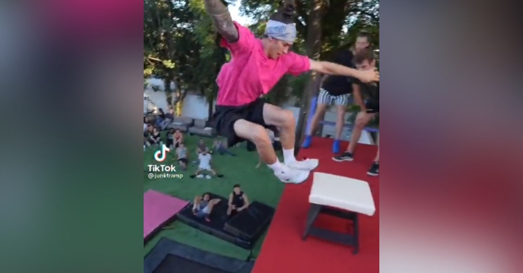 man mid jump from a giant trampoline on the ground