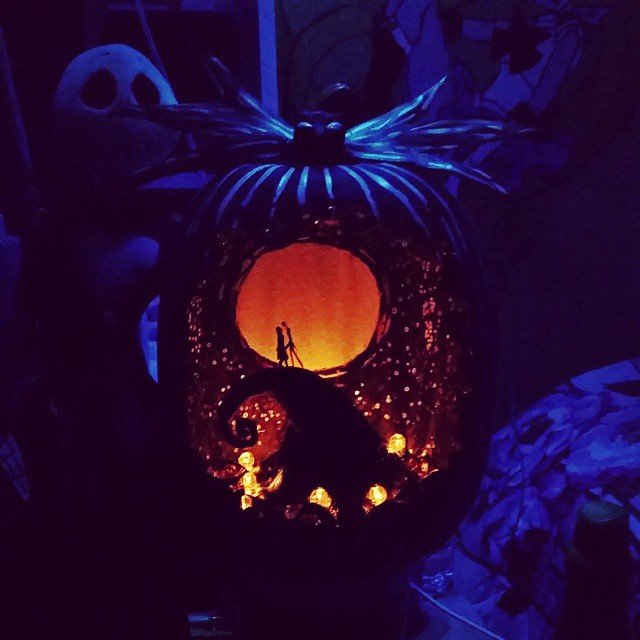 pumpkin carved to look like a scene from the movie the nightmare before christmas glowing in the dark