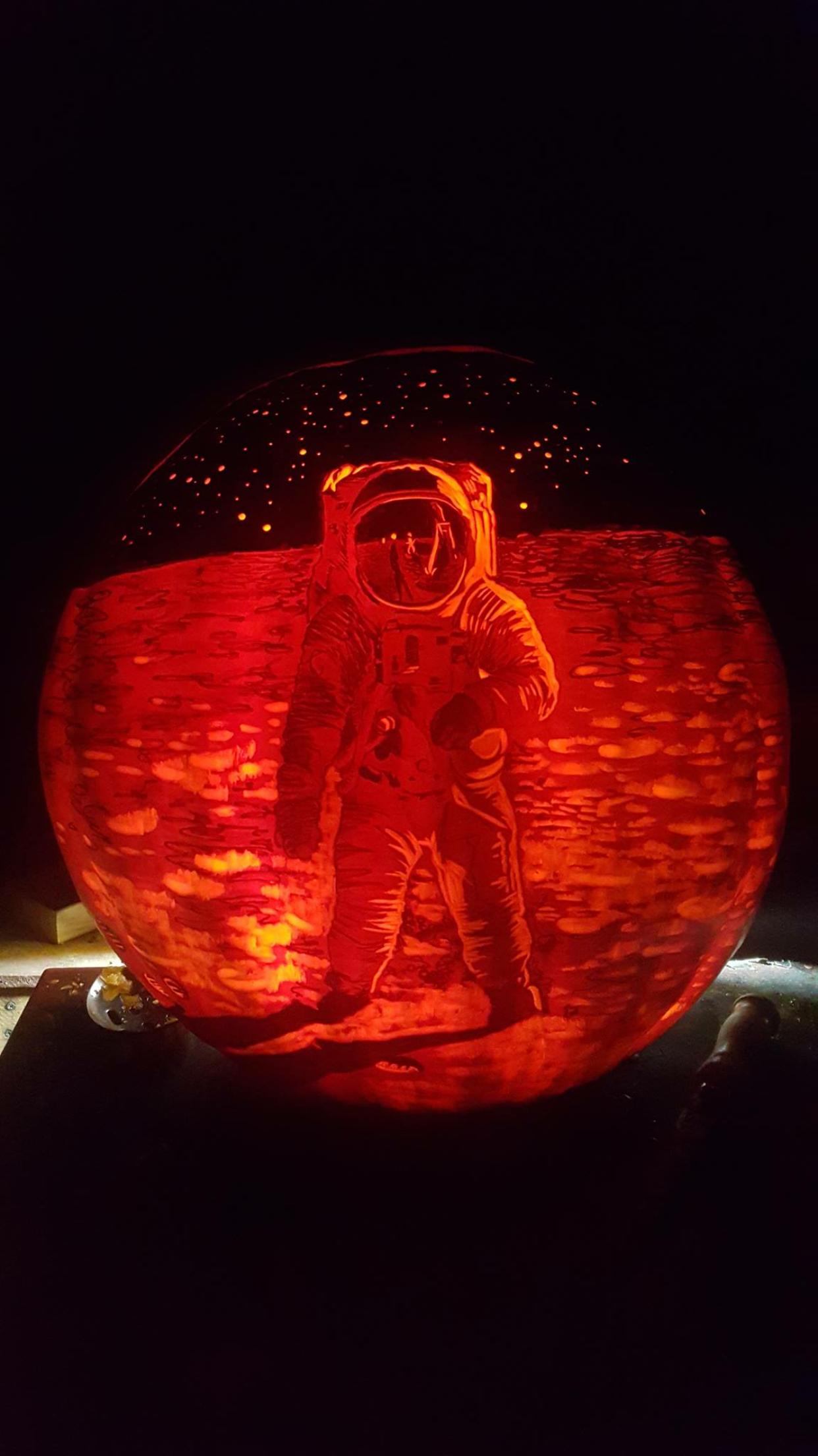 carved pumpkin made to look like an astronaut walking on the moon