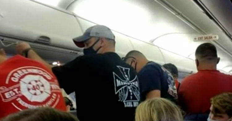 firefighters standing in airplane aisle