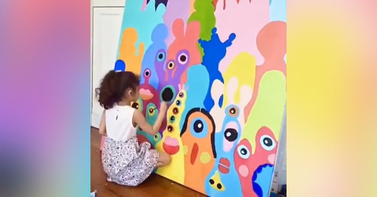 5 year old naomi liu sitting on the floor and painting colorful monsters on a large canvas