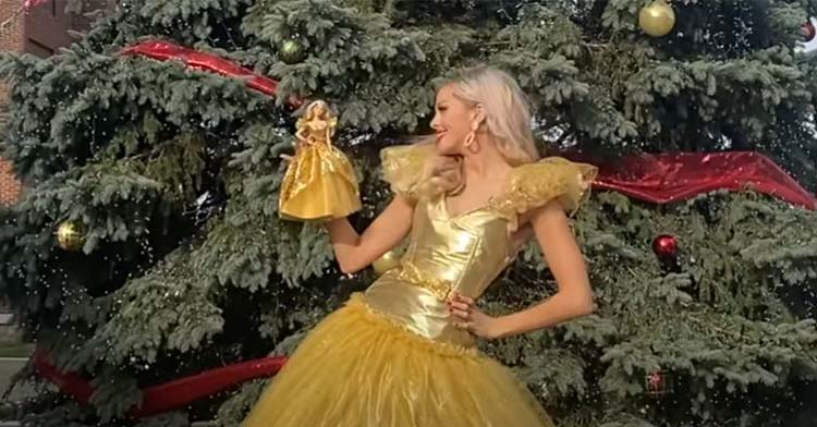 youtuber wearing yellow dress that matches barbie in her hand