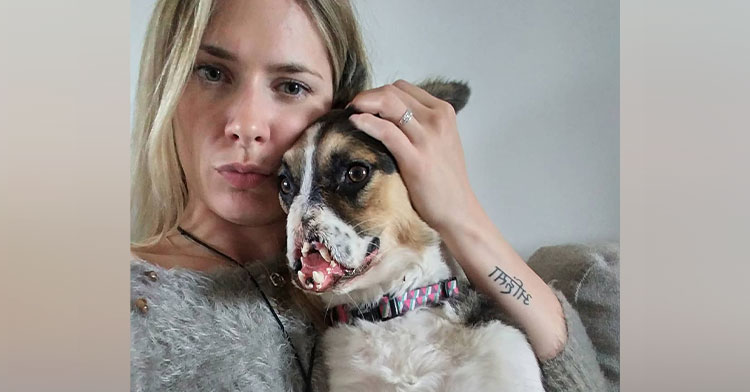 woman hugging dog with missing snout