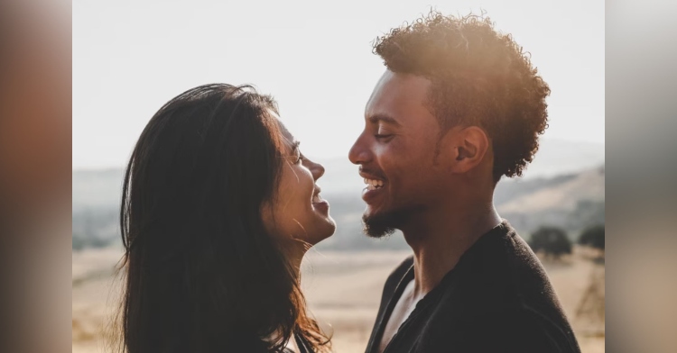 man and woman smiling as they stand face to face