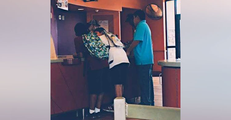 boys leaning against taco bell ordering counter