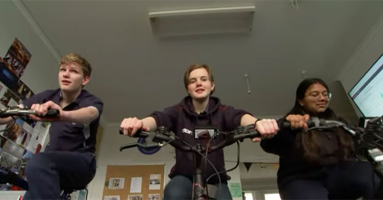 three students on indoor bikes
